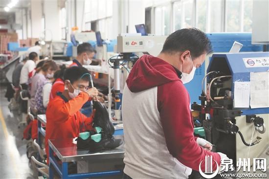 安踏員工正在車間忙碌地進(jìn)行生產(chǎn)（文珍 攝）